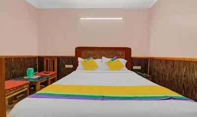 a bedroom with a large bed with wooden walls and a table at Itsy Hotels Rain Forest, 1 km from Rose Garden in Ooty