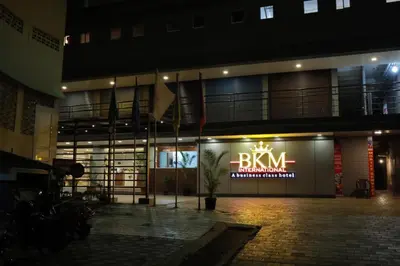 a building with a sign that says the bm pharmacy at Hotel BKM International in Tellicherry