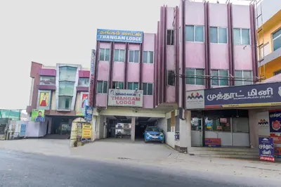 a pink building on the side of a street at SPOT ON Thangam Lodge in Coimbatore