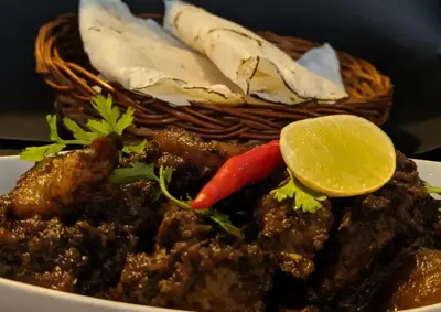 a plate of food with meat and a basket of food at Leela Farm Stay - Exclusive for Group Stay in Madikeri