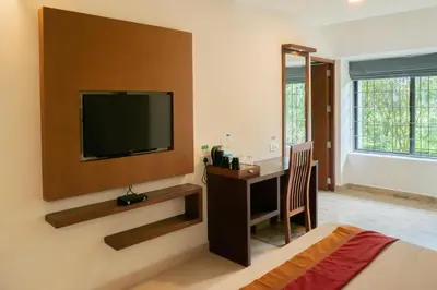 a room with a flat screen tv on a wall at The Sanihara Hotel & Resort in Vythiri