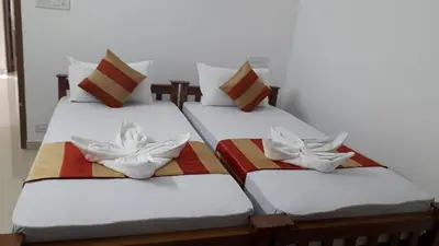three twin beds sitting next to each other in a room at GOLDEN VILLA in Ernakulam