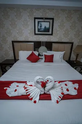 a bed with two swans made to look like hearts at Hotel Sidhartha Chalakudy in Kizhake Chālakudi