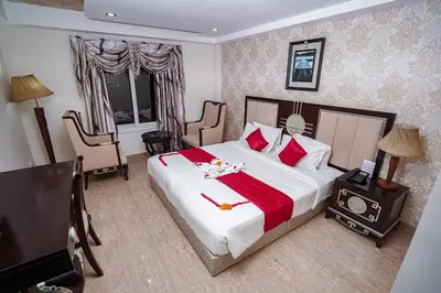a hotel room with a large bed with red pillows at Hotel Sidhartha Chalakudy in Kizhake Chālakudi