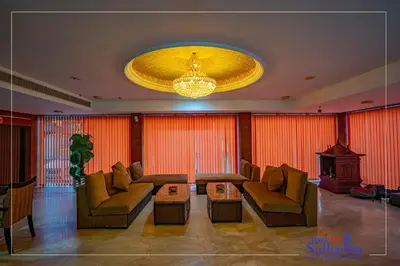 a living room with couches and a chandelier at Hotel Sidhartha Chalakudy in Kizhake Chālakudi