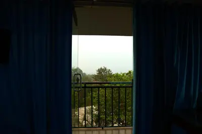 a view of a balcony from a room with a window at Wayanad Cave N Pillar Resort in Sultan Bathery