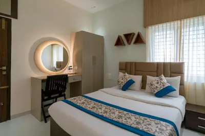 a bedroom with a bed and a desk and a mirror at THE SURRYA MAX RESIDENCY in Pollāchi