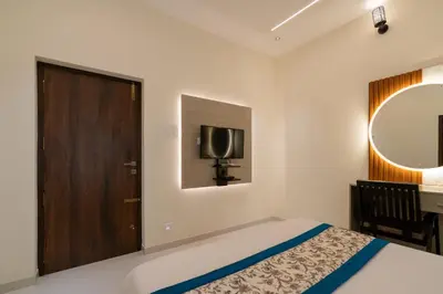 a bedroom with a bed and a tv and a mirror at THE SURRYA MAX RESIDENCY in Pollāchi