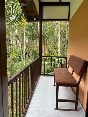 a wooden bench sitting on a balcony with trees at Standard family hut in Tariyod