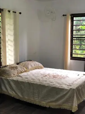 a bed in a white room with a window at Standard family hut in Tariyod