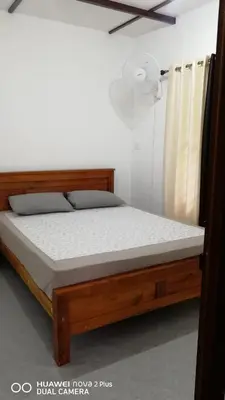 a bed in a bedroom with a wooden bed frame at Standard family hut in Tariyod