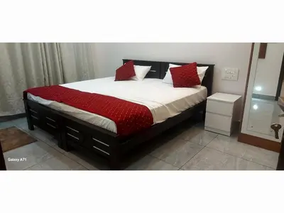a bedroom with a large bed with red pillows at Olive Inn Apartment in Alwaye