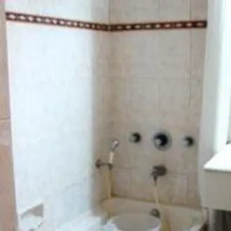 a bathroom with a tub and a sink and a toilet at Hotel Maurya Palace in Mysore