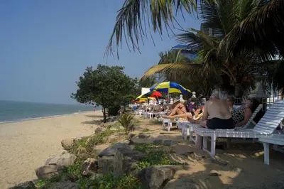 a group of people sitting on benches on the beach at Sealine Beach Resorts in Cherai Beach