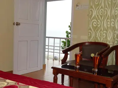 a room with a table with two glasses on it at Sealine Beach Resorts in Cherai Beach