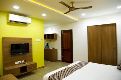 a bedroom with a bed and a flat screen tv at KB RESIDENCY in Kozhikode