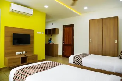 a hotel room with two beds and a tv at KB RESIDENCY in Kozhikode