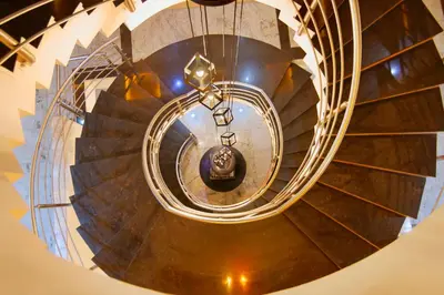 a spiral staircase in a building with a chandelier at Aishwarya Residency in Mysore