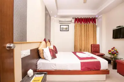 a hotel room with a bed and a chair at Aishwarya Residency in Mysore