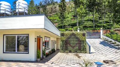 a white house with a fence next to it at Aira Residency Kothagiri by Lexstays in Kotagiri