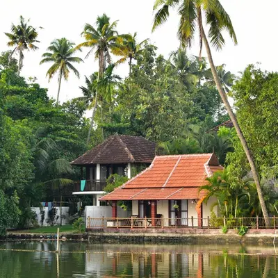 a house on the water with palm trees at Les 3 Elephants in Cherai Beach
