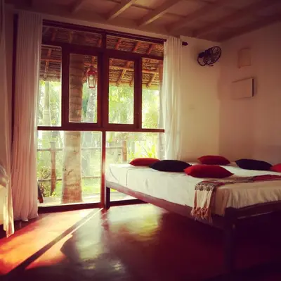a bedroom with two beds and a large window at Les 3 Elephants in Cherai Beach