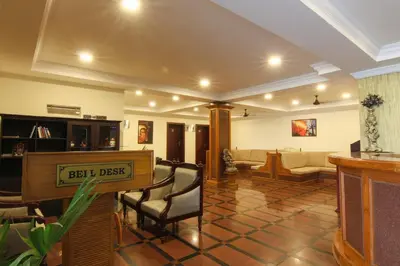 a lobby with a couch and a table and chairs at Hotel Kairali in Palakkad