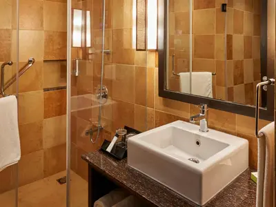 a bathroom with a sink and a shower at Club Mahindra Virajpet, Coorg in Virajpet