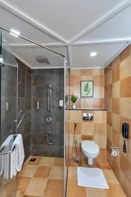 a bathroom with a shower and a toilet at Club Mahindra Virajpet, Coorg in Virajpet