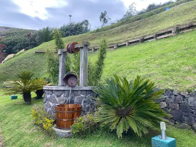 a fountain in the middle of a grassy hill at Mountain Retreat - A Hill Country Resort in Ooty