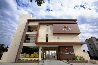 a front view of a building with a sign on it at Ponnis Hotel in Palani