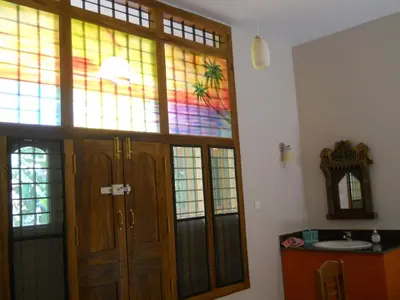 a bathroom with a stained glass window and a sink at CoconutCrazy! Homestay in Ottappālam