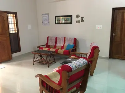 a living room with two couches and a table at CoconutCrazy! Homestay in Ottappālam