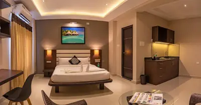 a bedroom with a bed and a table in a room at Aadya Elite in Mysore