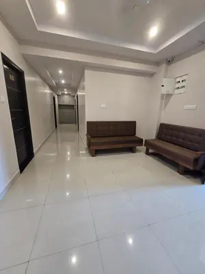 a waiting room with two benches in a building at Aadya Elite in Mysore