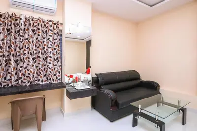 a waiting room with a leather couch and a table at Suvarna Suits in Mysore