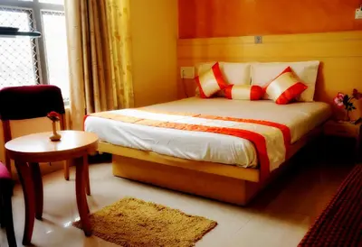 a bedroom with a bed with red and white pillows at Suvarna Suits in Mysore