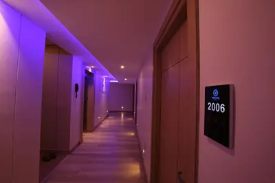 a hallway with purple lights on the walls at Mintotel Wayanad in Sultan Bathery
