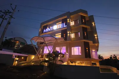 a building with a sign on it at night at Mintotel Wayanad in Sultan Bathery