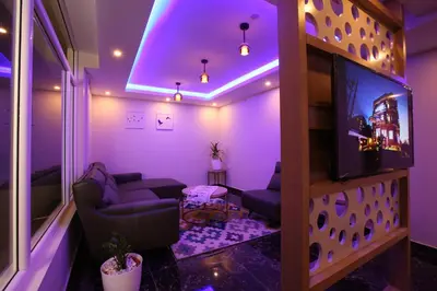 a living room with purple lighting and a tv at Mintotel Wayanad in Sultan Bathery