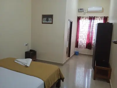 a bedroom with a bed and a window in a room at GRAND JP INN Near 2 km from Gundlupet bus stand in Gundlupet