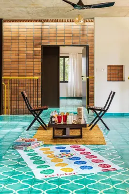 a room with two chairs and a table on the floor at SaffronStays Riverstone 3-BR Riverside Villa with Farm Views in Seringapatam