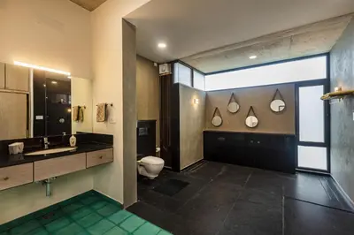 a bathroom with a toilet and a sink at SaffronStays Riverstone 3-BR Riverside Villa with Farm Views in Seringapatam