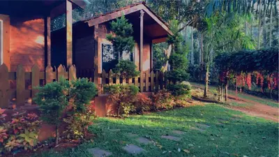 a wooden house with a fence in a yard at Coorg amodhini in Madikeri