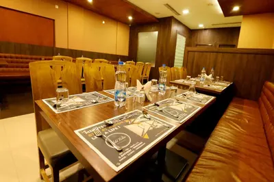 a dining room with a long table and chairs at Hotel Wilton in Sultan Bathery