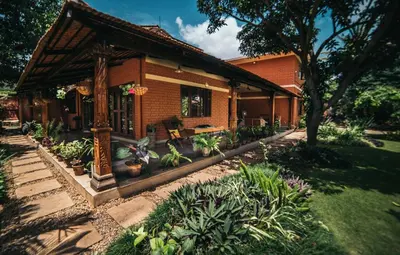 a house with a lot of plants in front of it at Gitanjali Homestay in Mysore
