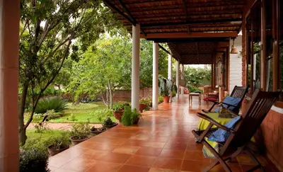 a porch with two rocking chairs on a house at Gitanjali Homestay in Mysore