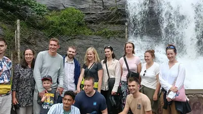 a group of people standing in front of a waterfall at Jewel Homes Thattekad - ISO 9001 certified Birding & Family Nature Stay in Thattakād