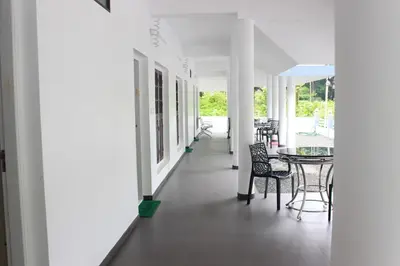 a hallway with chairs and a table in a building at Jewel Homes Thattekad - ISO 9001 certified Birding & Family Nature Stay in Thattakād