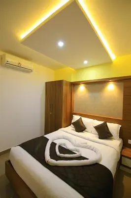 a bedroom with a large bed with a large white blanket at Royal Plaza Wayanad in Vythiri